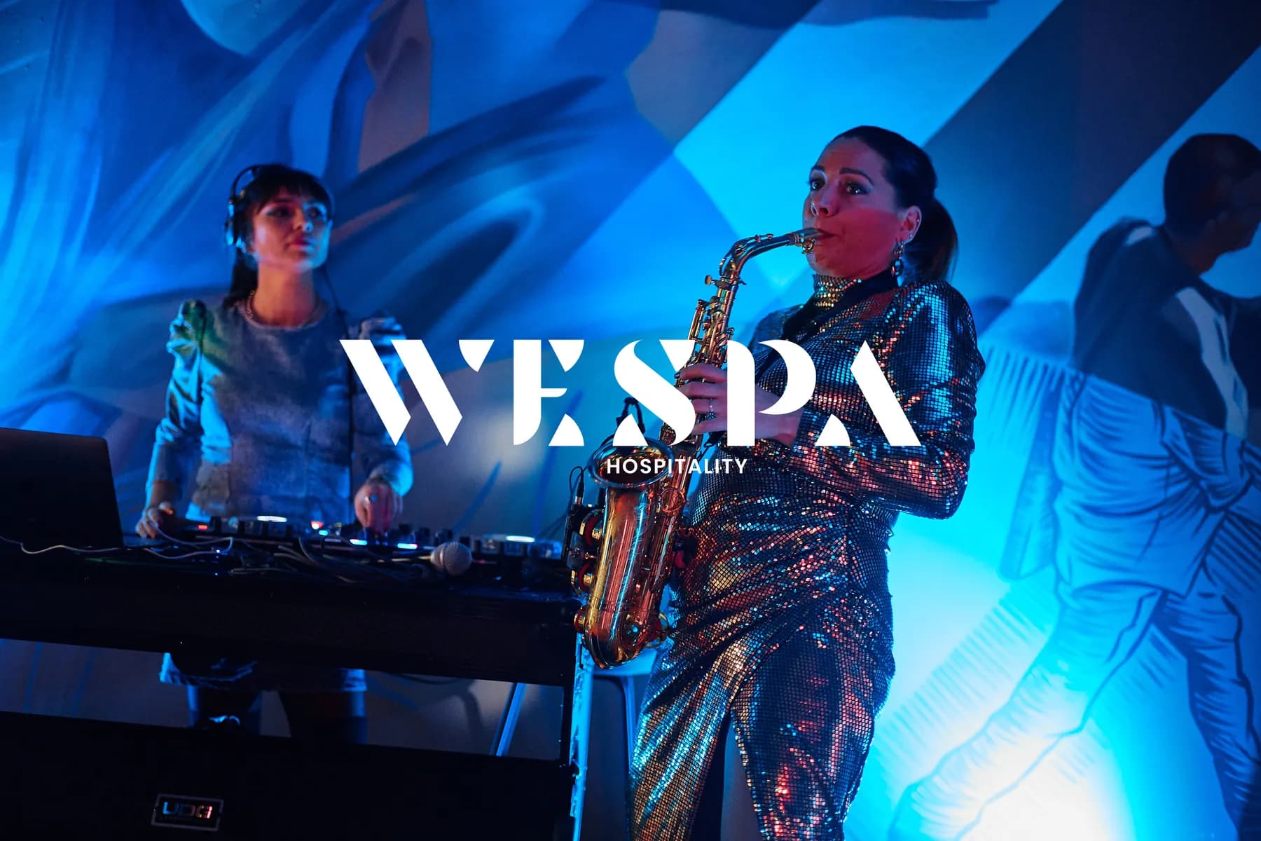 WESPA Hospitality in Zagreb: a DJ and a saxophonist performing under blue light at a WESPA event, with the WESPA Hospitality logo