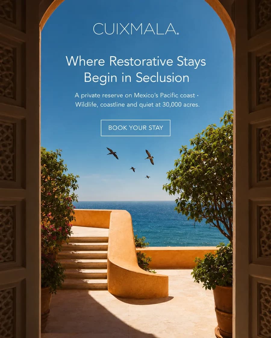 Cuixmala Meta ad: a carved doorway opening onto a terrace above the sea, headline Where Restorative Stays Begin in Seclusion and a Book your stay button